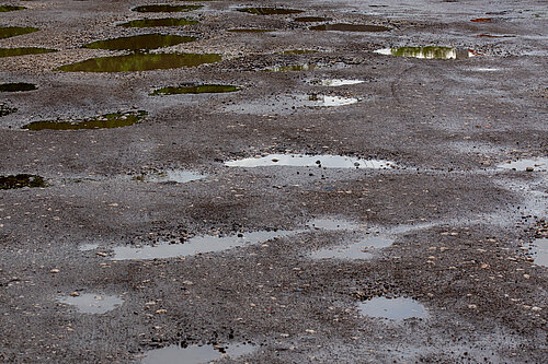 A road filled with potholes.