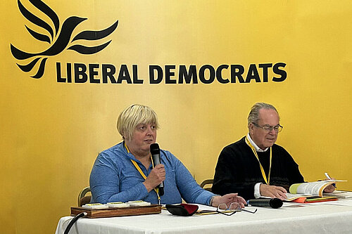 People in front of a Lib Dem conference sign