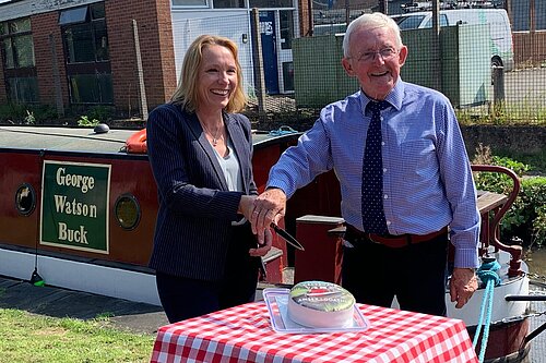 Helen helps cut the cake to celebrate 