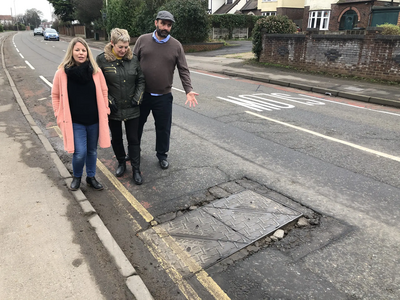 Sarah Sawyer, Linda Castle and Ian Williams at one of the manhole covers on Cheltenham Road