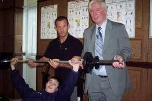 Paul tries out the Gym Equipment with a member of staff and a student.