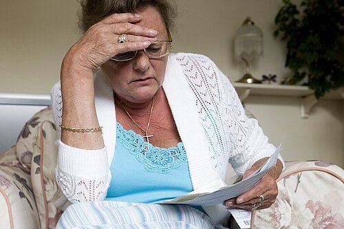 A lady looking at her bills.