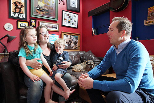 Richard Foord sat chatting to a mother with two young children on her lap