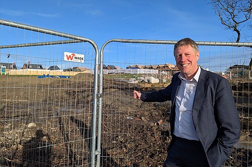 James standing by safety barriers at a building site. He looks excited - fr once he has reason as this is potentially where Willingdon's new health facility will be sited.