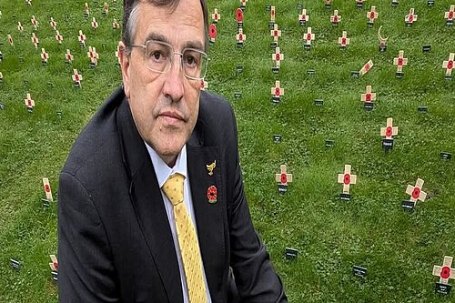 Martin Wrigley kneeling at a remembrance field