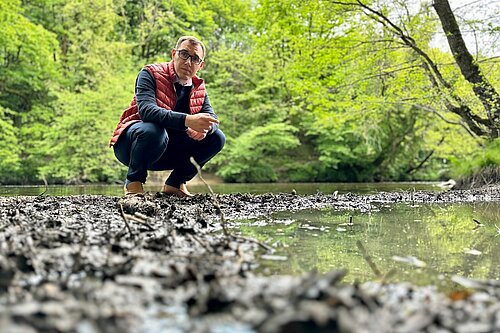 Tom Gordon crouching by the River Nidd