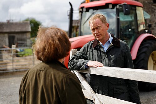 Tim listening to a farmer 