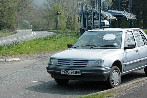 Used car with car transporter behind it