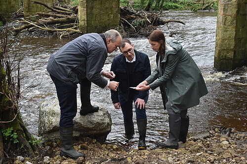 Tom Gordon, Ed Davey and Cllr Hannah Gostlow testing the water quality in the Nidd