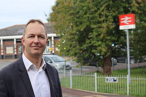 Richard Foord standing in front of the entrance to Honiton Railway Station