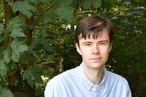 George Jezard standing in front of greenery