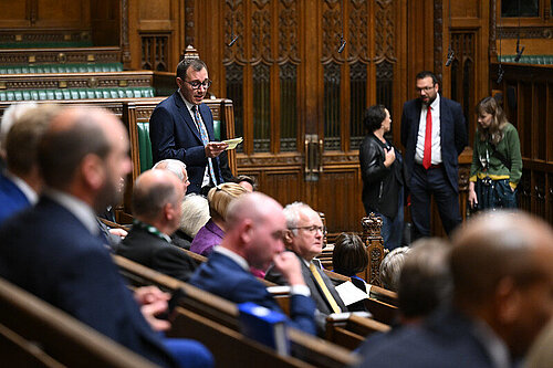 Tom Gordon stood speaking in the House of Commons Chamber