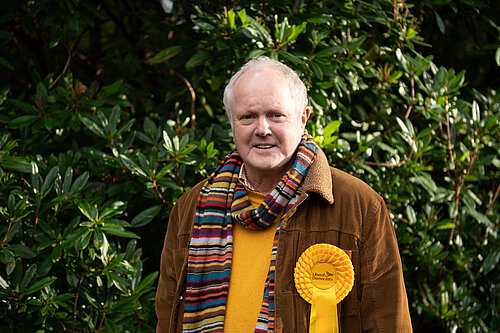 Clive outside with a yellow rosette on